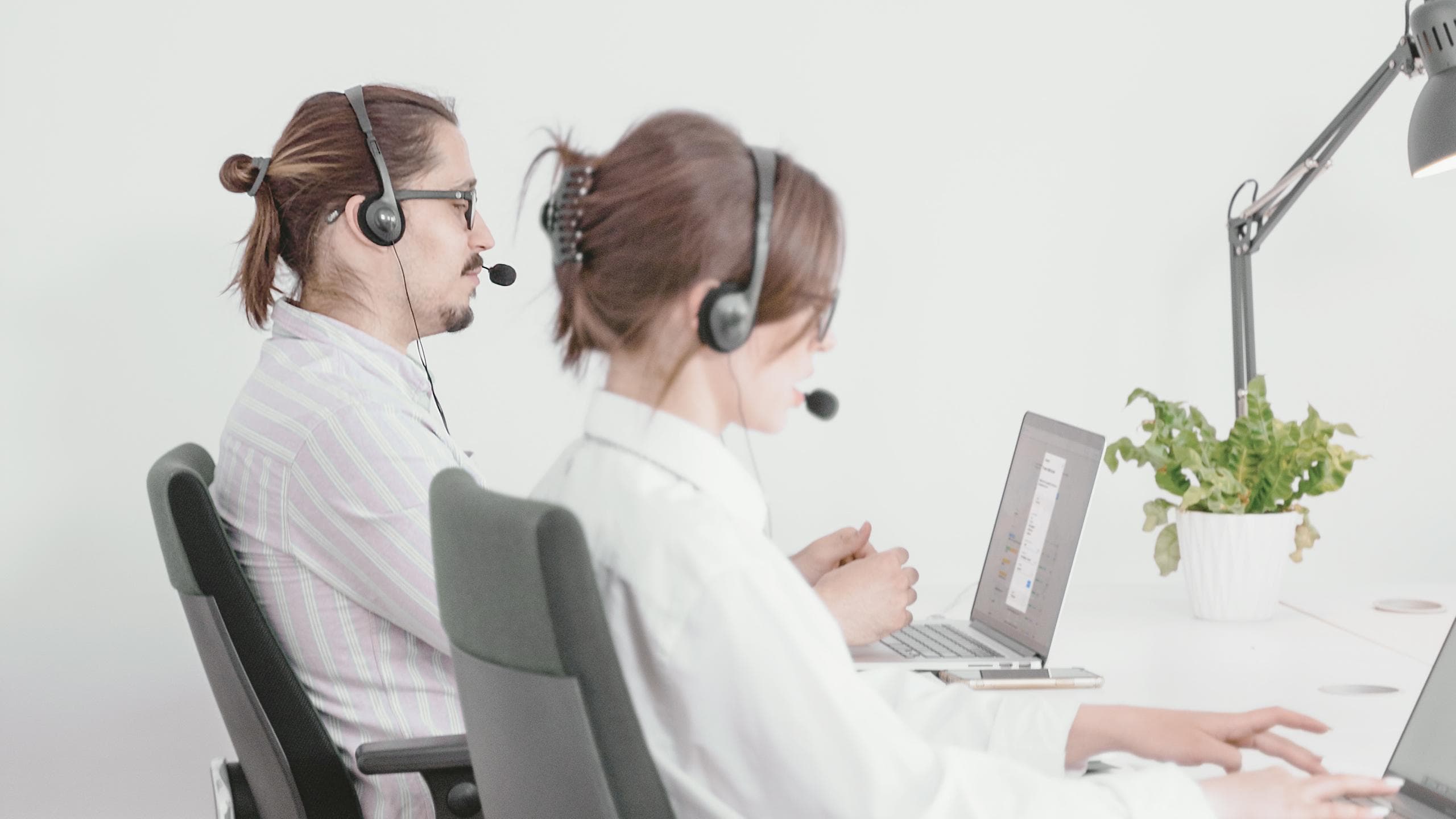 Mitarbeiter mit Headset vertreiben Versicherungen online mit der moneymeets App